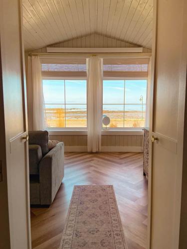 a living room with a couch and a large window at Couette et Marées - Maisonnette in Sainte-Luce-sur-Mer