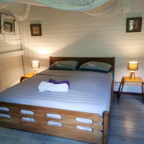 a bedroom with a large bed with two lamps at Gîte 1001 Nuits - SINBAD in Bouillante