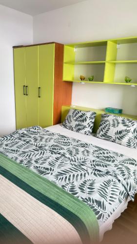 a bedroom with a bed with a black and white comforter at Apartman Green in Lukavica