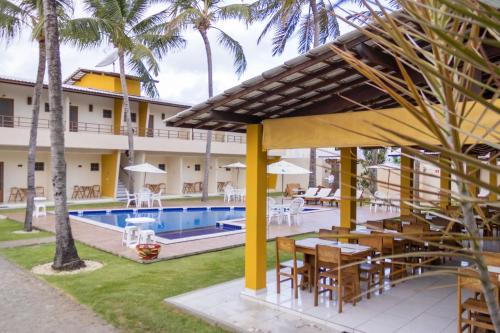 a view of a resort with a pool and tables at Pousada Paraiso da Barra in Barra de Santo Antônio
