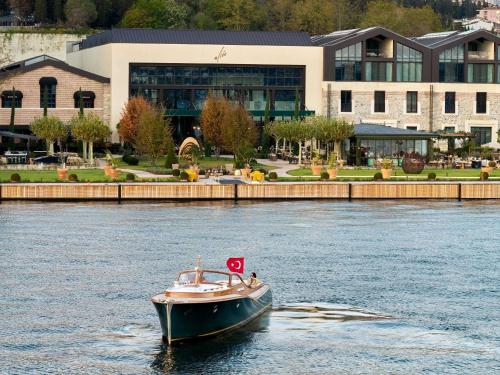 a small boat in the water in front of a building at Aliée Istanbul - A Paris Society Collection Hotel in Istanbul