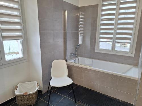 a bathroom with a white chair and a tub at Gîte du Craon de Ludes in Ludes