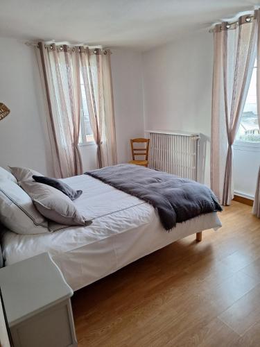 a bedroom with a bed and a table and windows at Gîte du Craon de Ludes in Ludes