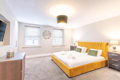 a bedroom with a bed and a dresser and windows at Northern Hideaways, Brown Bear House in Berwick-Upon-Tweed