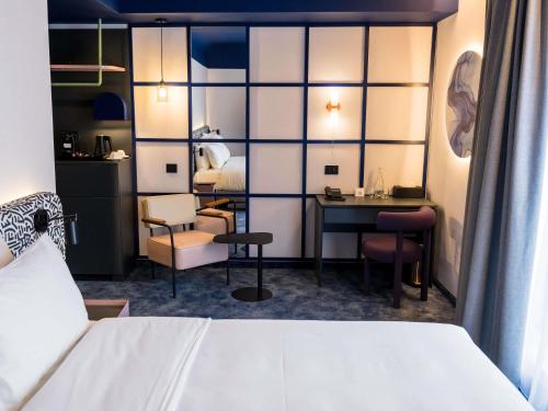 a hotel room with a bed and a desk at Mercure Bucharest Cantemir in Bucharest