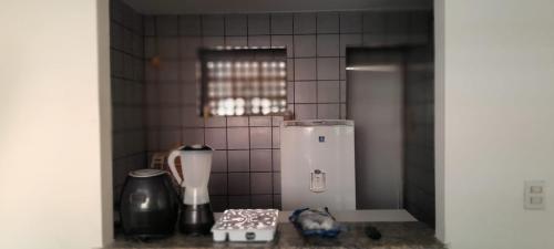 a kitchen with a small refrigerator and a tile wall at Casa duplex para lazer in Paulista