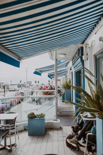 a balcony with tables and chairs and a marina at The White Rock Hotel in Hastings