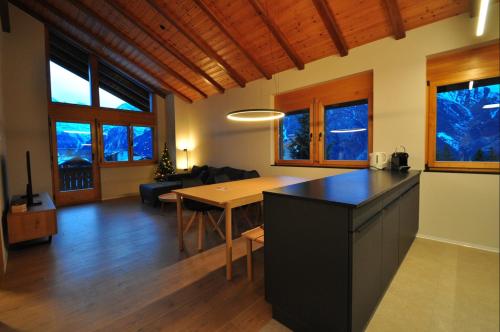 a kitchen and dining room with a table in a room at Tossu, Haus Metropol B in Grächen