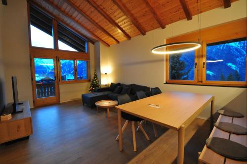 a living room with a table and a couch at Tossu, Haus Metropol B in Grächen