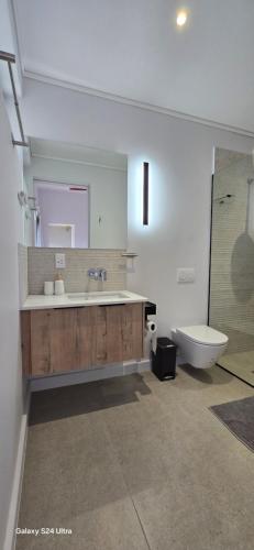 a bathroom with a tub and a sink and a toilet at Fynbos N Sea in Gansbaai