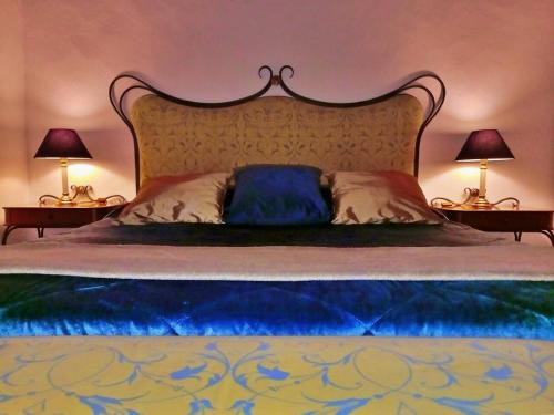 a bedroom with a large bed with two lamps at Vila Saraz Alqueva in Campinho