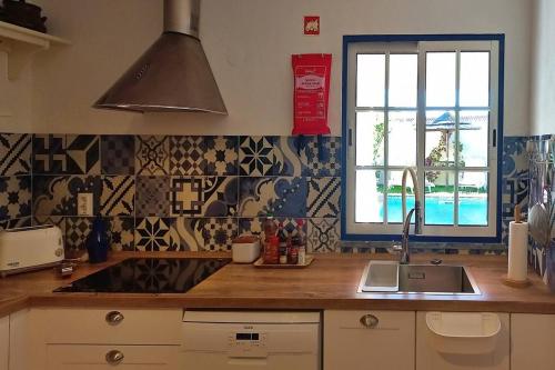 a kitchen with a sink and a window at Vila Saraz Alqueva in Campinho