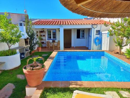 a swimming pool in front of a house at Vila Saraz Alqueva in Campinho