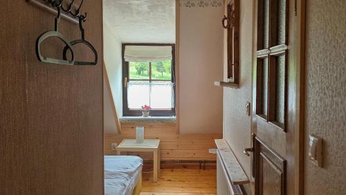 a small room with a bed and a window at Eskapada in Stronie Śląskie