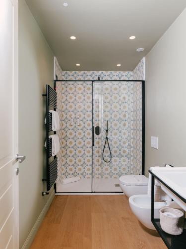 a bathroom with a shower and two toilets at Unconventional Sorrento Coast in Sant'Agnello