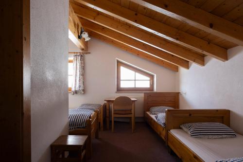a room with two beds and a table and a window at Hecherhaus in Schwaz