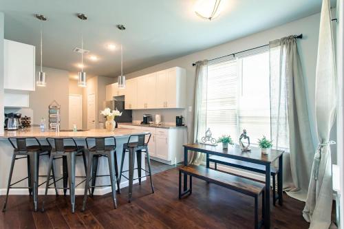 a kitchen with a table and some chairs in a room at 4BR 2,5BA Holiday Home in the Heart of Cowboy Nation in Arlington