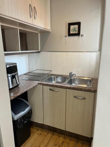 a small kitchen with a sink and a microwave at Bird Rock Sunrise in Gqeberha