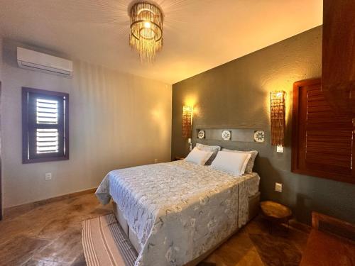 a bedroom with a bed and a chandelier at casa nova in Cruz