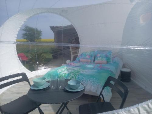 a room with a table and a bed in a tent at La chevauchée vers les étoiles in Yèvres