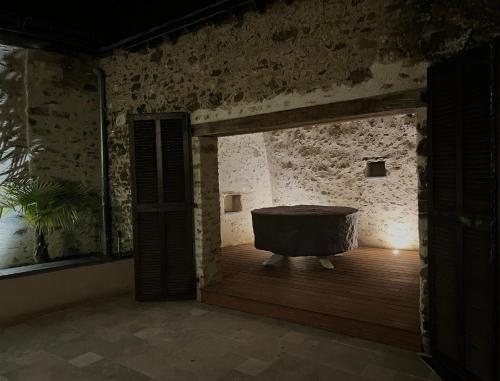a room with a bath tub in a stone wall at La Pierre du Bonheur in Saint-Denis-dʼAnjou