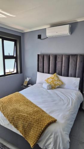 a bedroom with a large white bed with yellow pillows at KeAnna STAYS units in Tsumeb