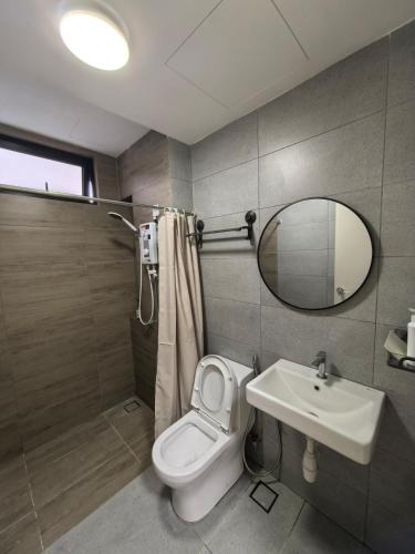 a bathroom with a toilet and a sink and a mirror at Batu Kawan Sunset Seaview Condo near Ikea & Design Village in Batu Kawan
