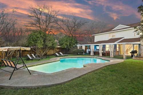 a swimming pool in the yard of a house at Elegant 5BR 2,5BA Holiday Home with Pool, Jacuzzi, BBQ, and Cinema Room in Farmers Branch