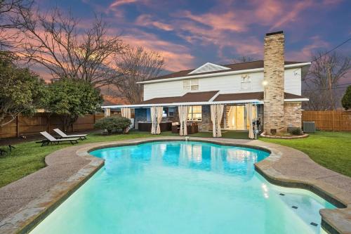 a swimming pool in front of a house at Elegant 5BR 2,5BA Holiday Home with Pool, Jacuzzi, BBQ, and Cinema Room in Farmers Branch