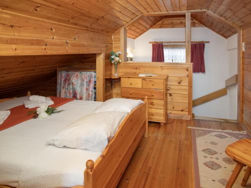 a bedroom in a log cabin with a bed and a desk at Chalet Kil-Ukru by Interhome in Ovronnaz