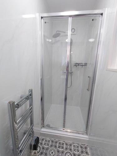 a shower with a glass door in a bathroom at Centra Woodgreen in London
