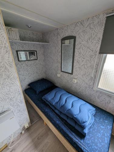 a small bedroom with a blue bed in a room at Beach Resort Kamperland - 1747 in Kamperland