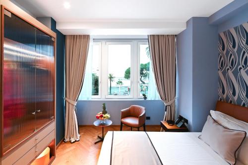 a bedroom with a bed and a window and a chair at Hotel Astoria in Rapallo
