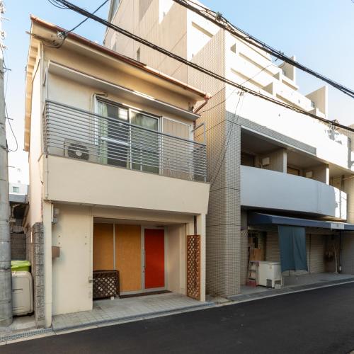 an apartment building with a balcony on a street at Private house YOURSとなり in Osaka