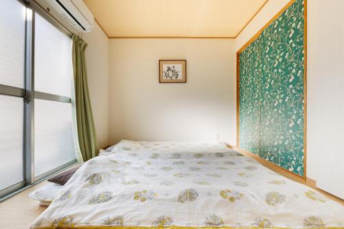 a bedroom with a bed and a large window at Private house YOURSとなり in Osaka