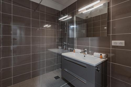 un bagno con lavandino e specchio di Les Sarments a Le Lavandou