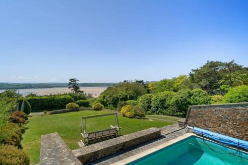 a swimming pool in the yard of a house at Beautiful Home with Pool Overlooking Camel Estuary in Roche