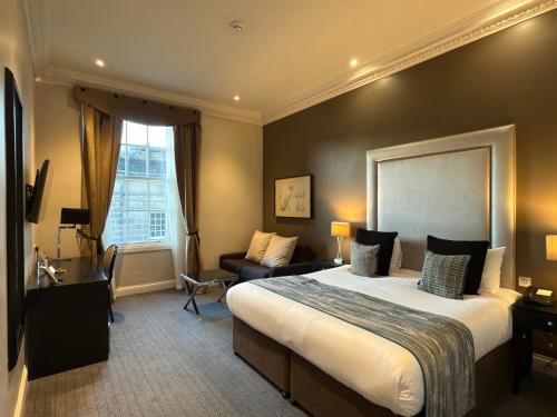 a hotel room with a large bed and a couch at Fraser Suites Edinburgh in Edinburgh