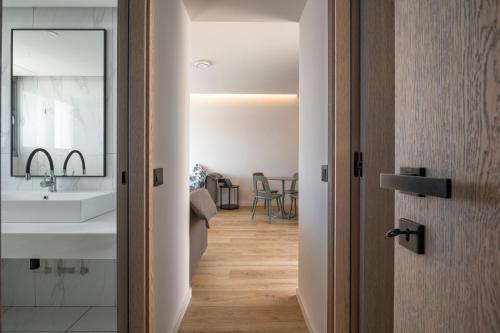 ein Badezimmer mit Waschbecken und Spiegel in der Unterkunft Adrina Grand Hotel in Panormos Skopelos