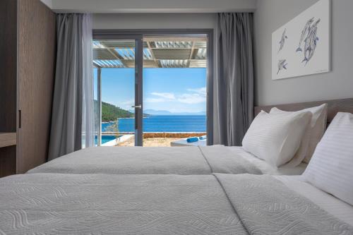 ein Schlafzimmer mit Bett und Meerblick in der Unterkunft Adrina Grand Hotel in Panormos Skopelos