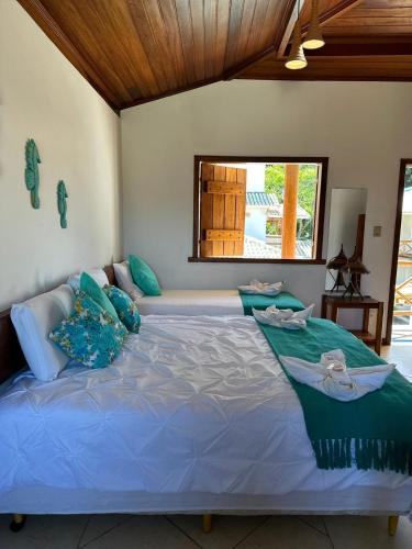 a large bed with blue pillows in a room at Pousada Tetiaroa in Barra Grande