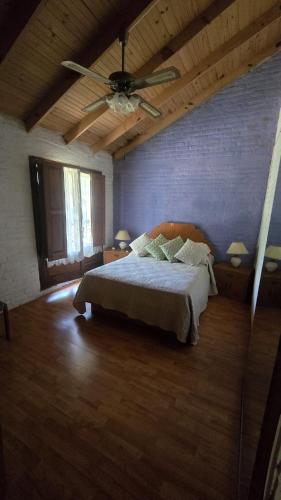 a bedroom with a bed and a ceiling fan at La Casa de Lili in La Pedrera