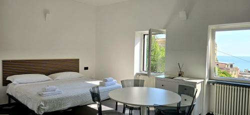 a bedroom with a bed and a table and a window at Cinque Terre Homes by Bluchalet in Riomaggiore