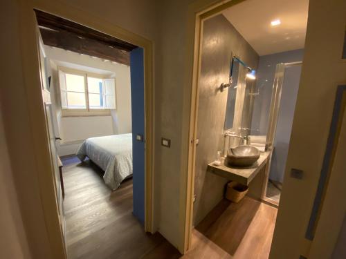 a bedroom with a bed and a bathroom with a mirror at LuccaStay 99 in Lucca