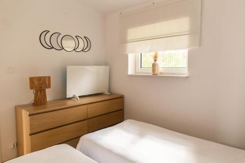 a bedroom with two beds and a mirror and a window at Przystań Kormoran in Czarna Wieś