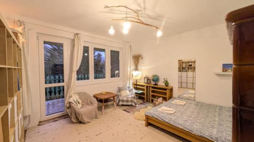 a bedroom with a bed and a desk and windows at Gesztenyés Backpackers in Kőszeg