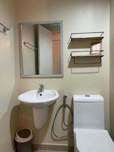 ein Badezimmer mit Waschbecken, Toilette und Spiegel in der Unterkunft KBrothers - Chic Studio in the Heart of it All! in Cagayan de Oro