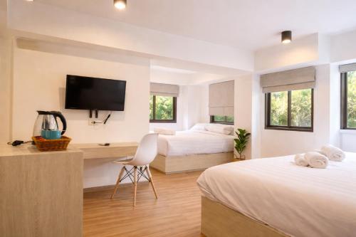 a bedroom with two beds and a flat screen tv at Saffron Hill Minburi in Min Buri