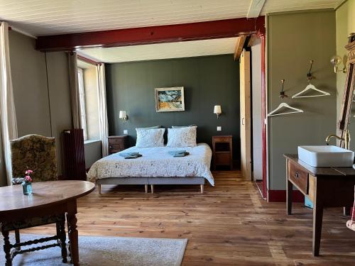 a bedroom with a bed and a sink at Moulin de Maupoy in Saint-Symphorien-de-Marmagne