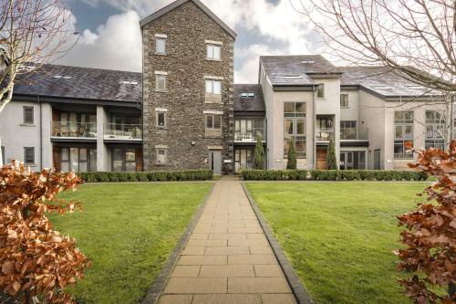 an exterior view of a large house with a lawn at Exceptional 3 Bedroom River View Apartment - Pass the Keys in Ulverston
